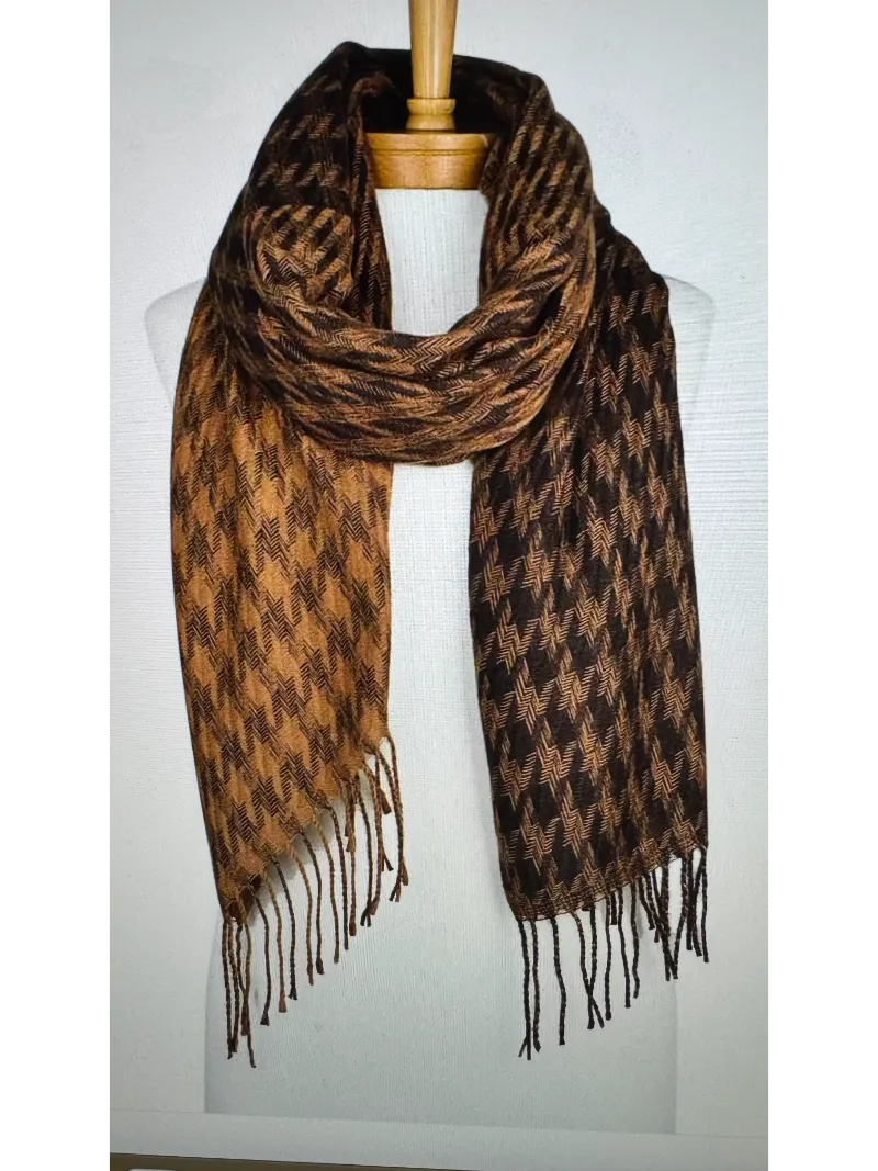 A cosy brown and black houndstooth scarf with a fringe on a mannequin body tied in a front knot
