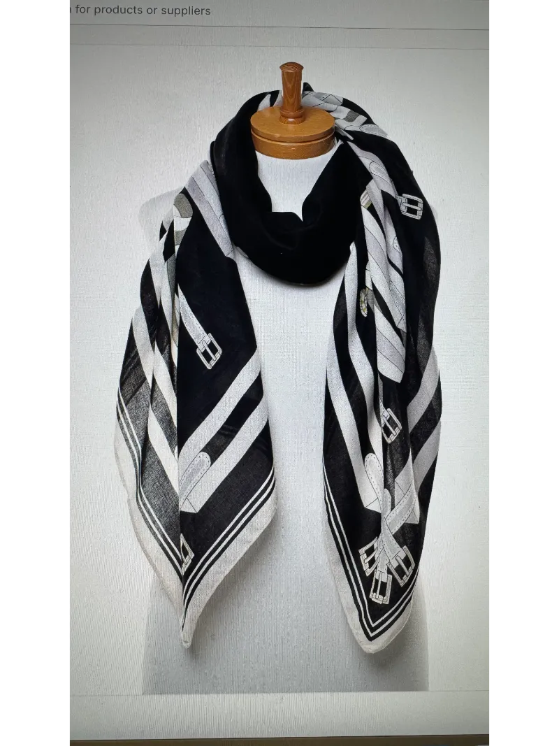 A black ,cream and silver scarf on a mannequin body tied in a front knot with images of belts