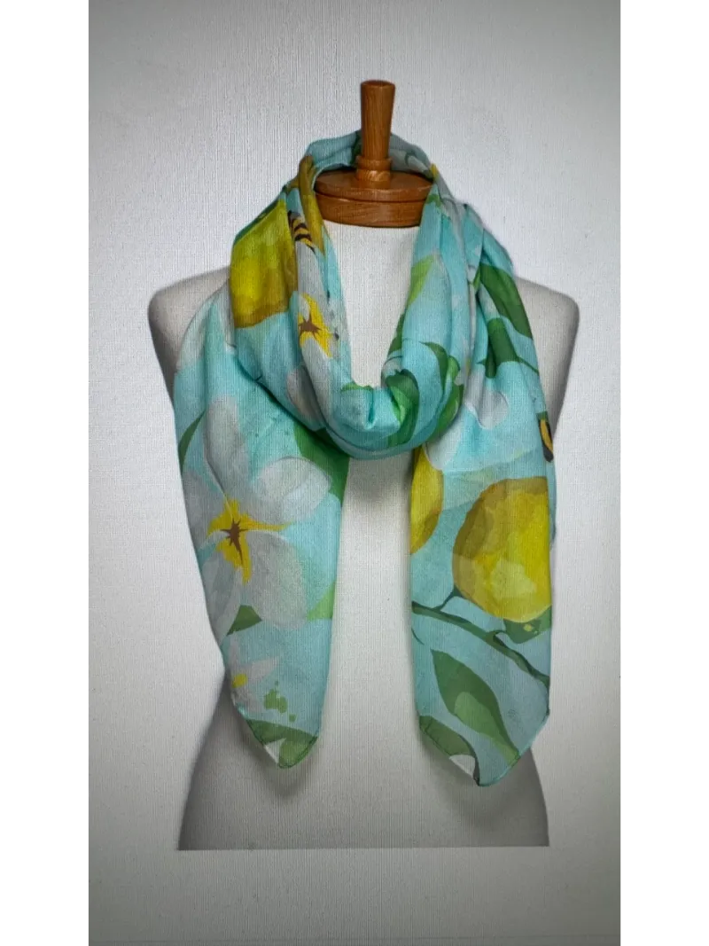 A front roll Scarf on a mannequin body tied in a knot with images of bees and lemons on an aqua base