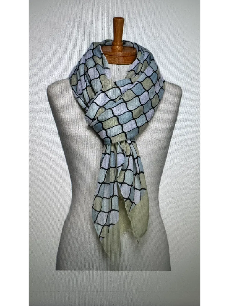 A scarf on a mannequin body tied in a twist knot with a mosaic pattern in soft lime green , aqua and white